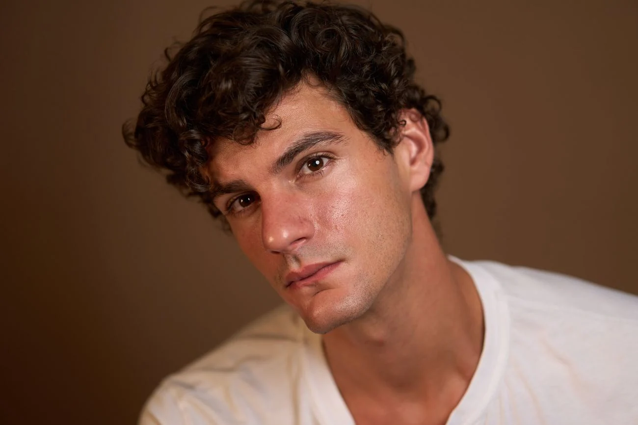 Color actor headshot against a warm brown backdrop