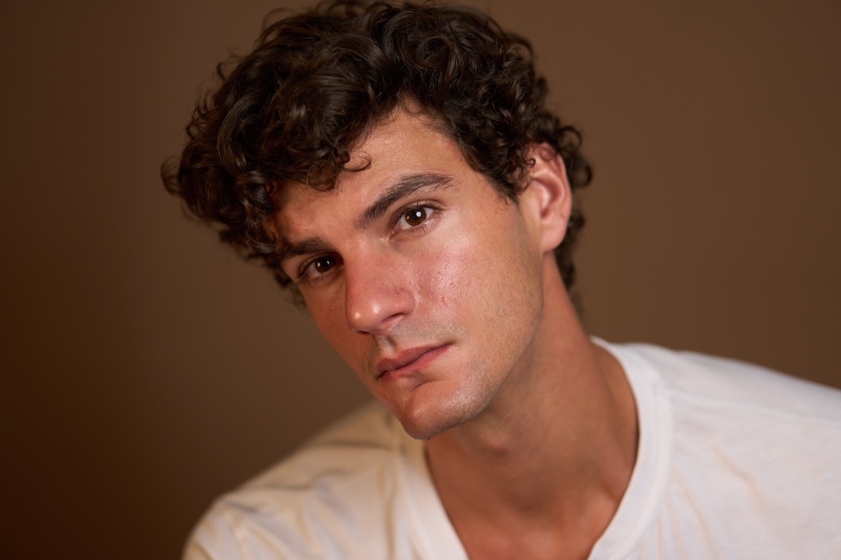 Color actor headshot against a warm brown backdrop