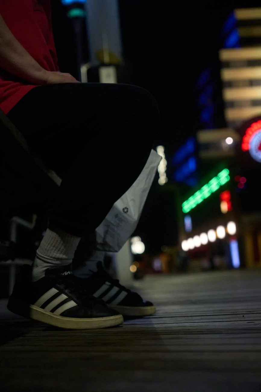 Lifestyle night photo of sneakers on a Charlotte boardwalk with city lights