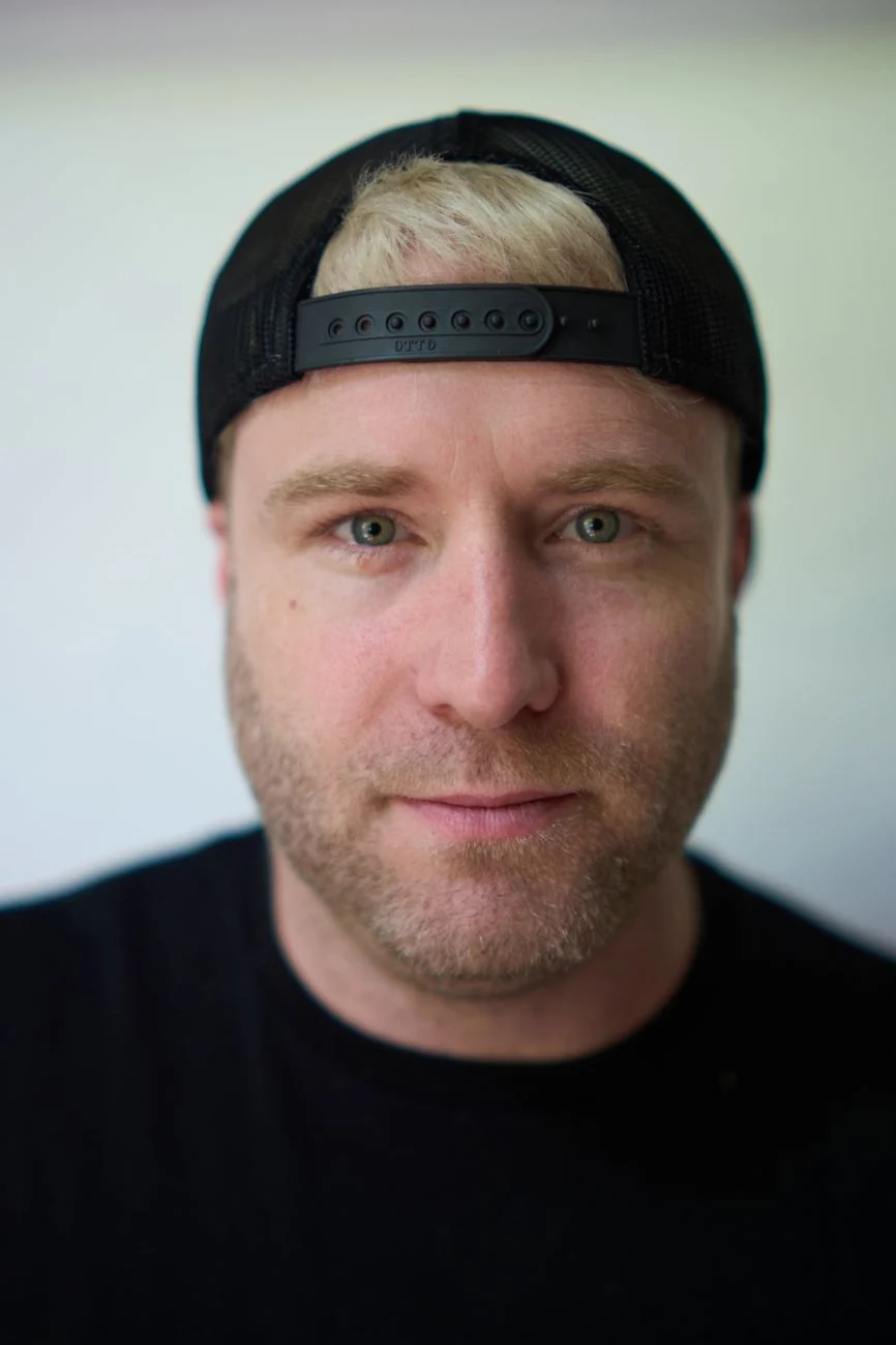 Professional portrait of a man in a backwards cap, close up